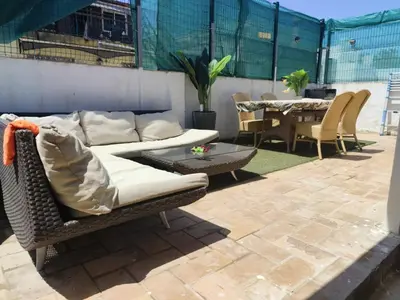 a couch and a table and chairs on a patio at Serenity Boutique Home in Chiclana de la Frontera