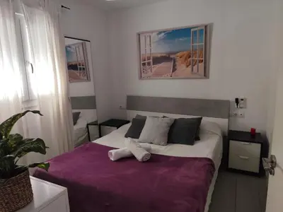 a bedroom with a bed with a purple blanket at Serenity Boutique Home in Chiclana de la Frontera