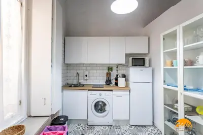 a kitchen with white cabinets and a washer and dryer at Adolfo de Castro by Cadiz Time in Cádiz