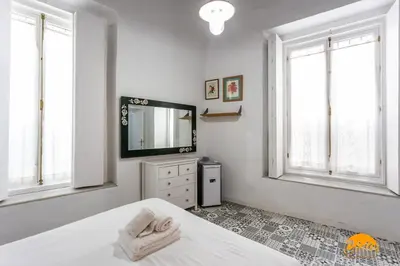 a white bedroom with a bed and a television at Adolfo de Castro by Cadiz Time in Cádiz