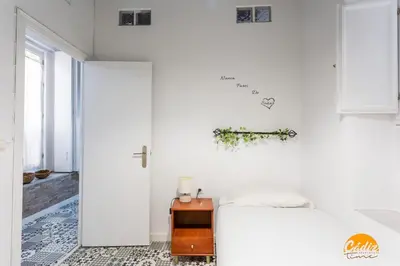 a white bedroom with a bed and a table at Adolfo de Castro by Cadiz Time in Cádiz