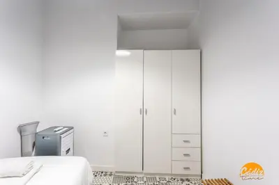 a white bedroom with a bed and white cabinets at Adolfo de Castro by Cadiz Time in Cádiz