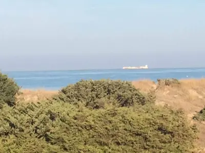 a view of the ocean with a building in the distance at Hotel Novomar in Chiclana de la Frontera
