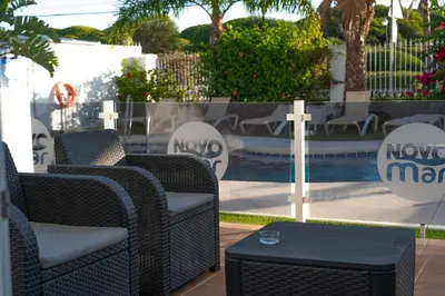 a group of wicker chairs and a cross on a patio at Hotel Novomar in Chiclana de la Frontera
