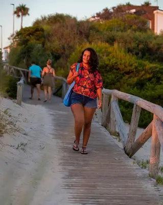a woman walking down a wooden bridge at Hotel Novomar in Chiclana de la Frontera