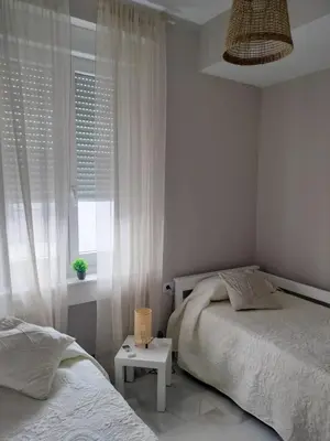 a bedroom with two beds and a window at plaza esteve in Jerez de la Frontera