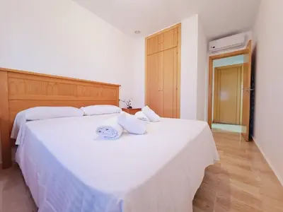 a bedroom with two beds with white sheets at Apartamentos Turísticos Taymar in Chiclana de la Frontera