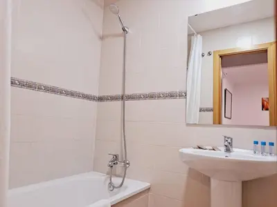 a white bathroom with a sink and a shower at Apartamentos Turísticos Taymar in Chiclana de la Frontera