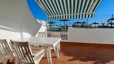 a white table and chairs on a balcony with a view of the ocean at Apartamento en primera linea de playa in Novo Sancti Petri