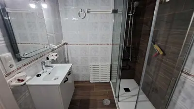 a white bathroom with a shower and a sink at Apartamento en primera linea de playa in Novo Sancti Petri