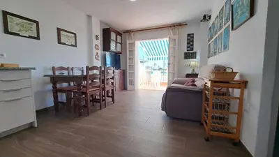 a kitchen and dining room with a table and chairs at Apartamento en primera linea de playa in Novo Sancti Petri