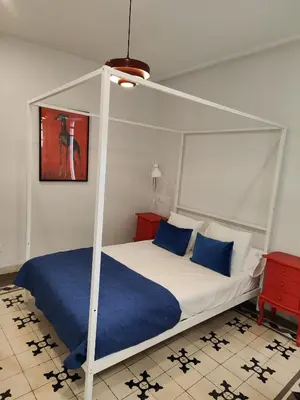 a bedroom with a white canopy bed with blue pillows at castellano home in Jerez de la Frontera