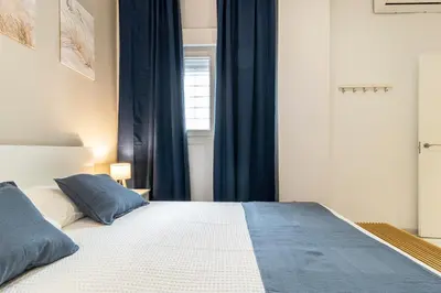 a bedroom with a large bed with blue curtains at Jerez Boutique by Sanz in Jerez de la Frontera