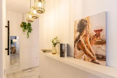 a living room with a painting of a woman drinking wine at Jerez Boutique by Sanz in Jerez de la Frontera