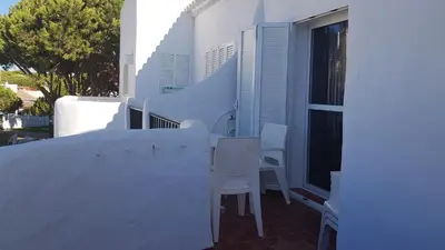 a balcony with white chairs and a window at Apartamento en primera línea de playa en 2ª planta in Novo Sancti Petri