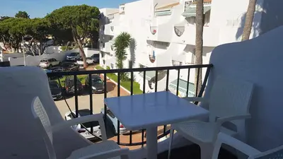 a blue table and chairs on a balcony with a street at Apartamento en primera línea de playa en 2ª planta in Novo Sancti Petri