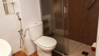 a bathroom with a toilet and a shower at Apartamento en primera línea de playa en 2ª planta in Novo Sancti Petri