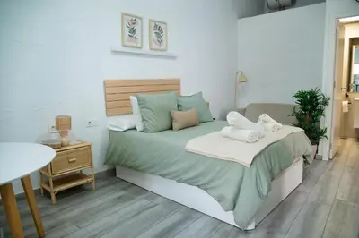 a bedroom with a large bed and a table at Apartamento La Catavina in Jerez de la Frontera