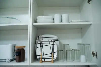 a white cabinet filled with dishes and a mirror at Apartamento La Catavina in Jerez de la Frontera