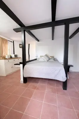 a bedroom with a large bed with black beams at Finca Feliciano in Novo Sancti Petri