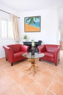 a living room with two red couches and a table at Finca Feliciano in Novo Sancti Petri