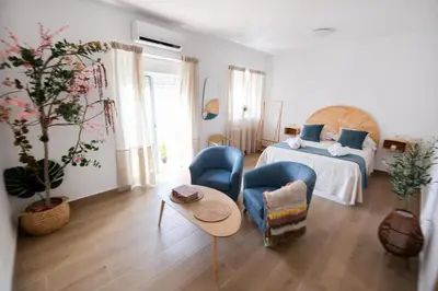 a bedroom with a bed and two chairs and a table at La Zarzamora in Jerez de la Frontera