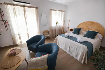 a bedroom with a large bed and two chairs at La Zarzamora in Jerez de la Frontera