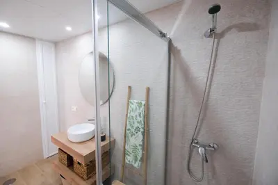 a bathroom with a shower with a sink and a mirror at La Zarzamora in Jerez de la Frontera