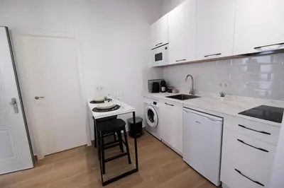 a white kitchen with a sink and a dishwasher at La Zarzamora in Jerez de la Frontera