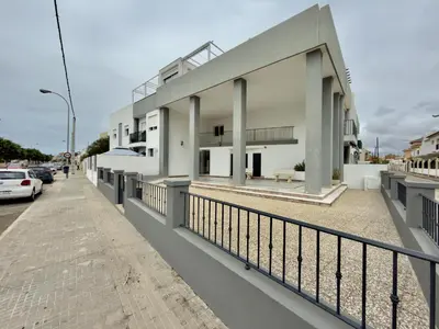 a white building with columns on a street at RESIDENCIAL EL CANO in Rota