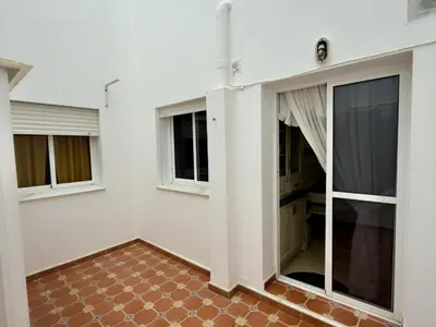 an empty room with windows and a brick floor at RESIDENCIAL EL CANO in Rota