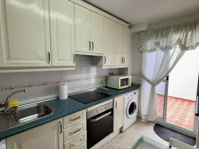 a kitchen with white cabinets and a sink and a dishwasher at RESIDENCIAL EL CANO in Rota