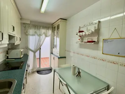 a kitchen with a table and a sink and a window at RESIDENCIAL EL CANO in Rota