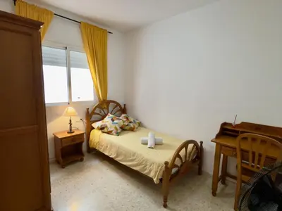 a bedroom with a bed and a desk and a window at RESIDENCIAL EL CANO in Rota