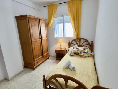 a bedroom with a bed and a cabinet and a window at RESIDENCIAL EL CANO in Rota