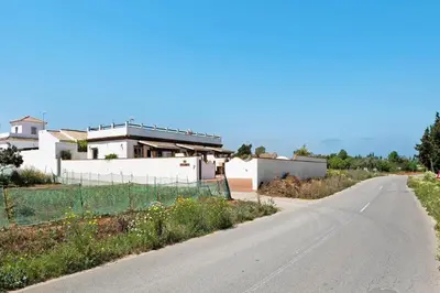 an empty road in front of a white house at Casas el Palomar in Conil de la Frontera