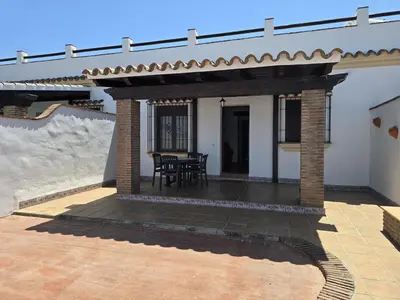a patio with a roof and a table on it at Casas el Palomar in Conil de la Frontera