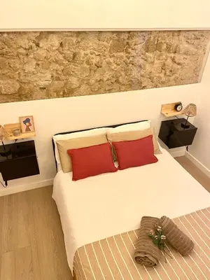 a bedroom with a large bed with red pillows at Casa Cristina in Cádiz