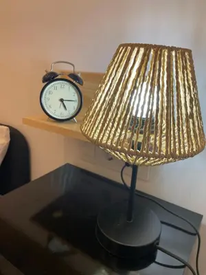 a lamp on a table with a clock on a shelf at Casa Cristina in Cádiz