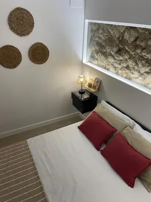 a bedroom with a bed with two red pillows at Casa Cristina in Cádiz