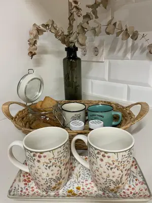 a tray with three cups and a basket with flowers at Casa Cristina in Cádiz