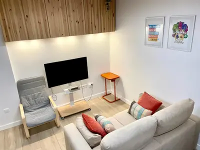 a living room with a couch and a tv and a chair at Casa Cristina in Cádiz