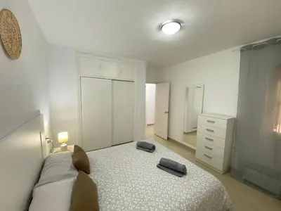 a bedroom with a bed and a dresser at Banda Playa Home, Pleno Centro in Sanlúcar de Barrameda