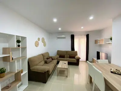 a living room with a couch and a table at Banda Playa Home, Pleno Centro in Sanlúcar de Barrameda