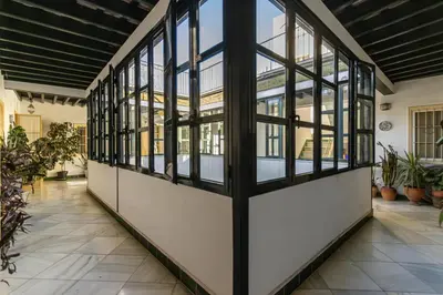 a hallway with windows and potted plants at NUEVO-NEW Casa Palacio M anuela in Jerez de la Frontera