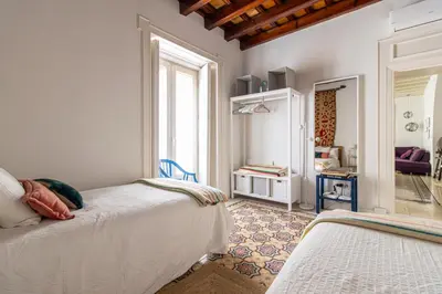 a bedroom with two beds and a mirror at NUEVO-NEW Casa Palacio M anuela in Jerez de la Frontera