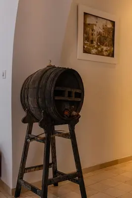 a wooden barrel sitting on a stand next to a wall at NUEVO-NEW Casa Palacio M anuela in Jerez de la Frontera