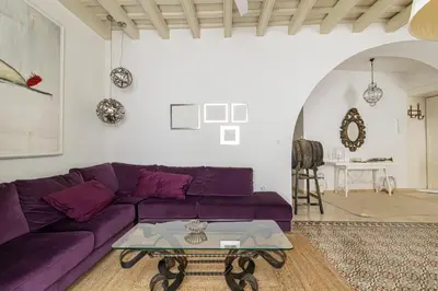 a living room with a purple couch and a table at NUEVO-NEW Casa Palacio M anuela in Jerez de la Frontera