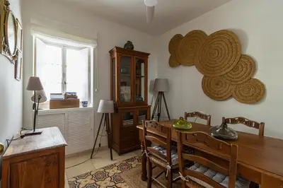 a dining room with a wooden table and a window at NUEVO-NEW Casa Palacio M anuela in Jerez de la Frontera