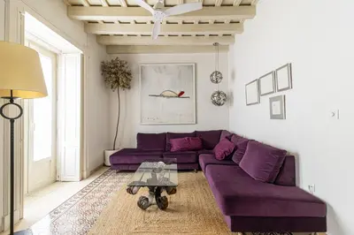 a living room with a purple couch and a table at NUEVO-NEW Casa Palacio M anuela in Jerez de la Frontera